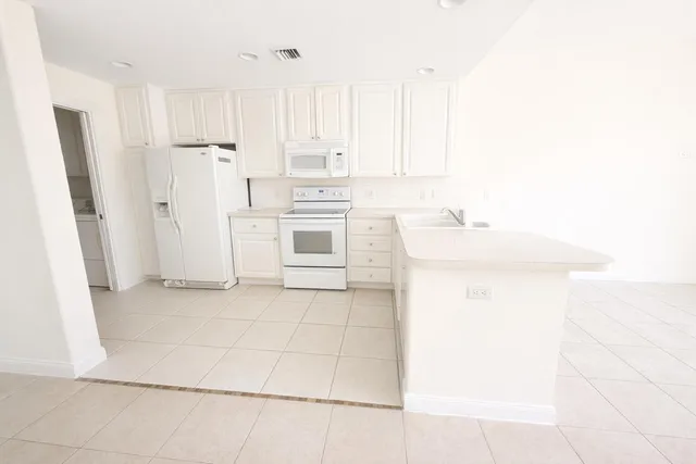 an empty room with a ceiling fan and carpet
