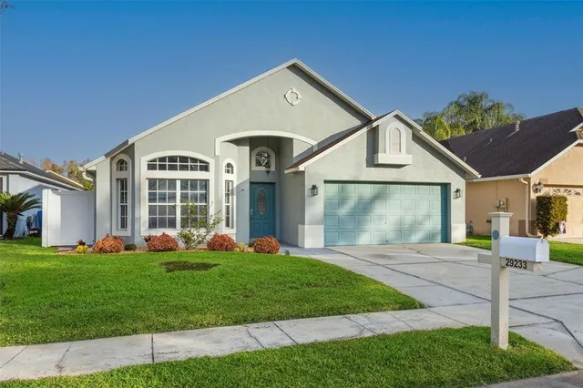 a front view of a house with a yard and trees