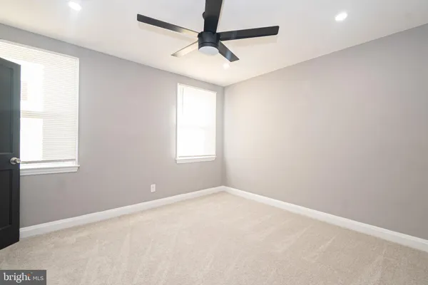 an empty room with windows and fan