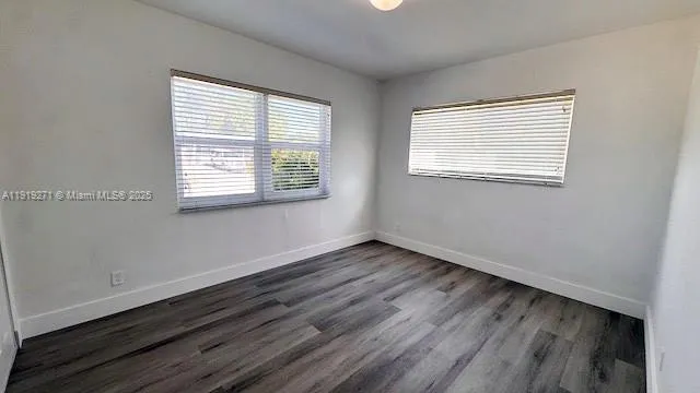 a view of a room with wooden floor and a window