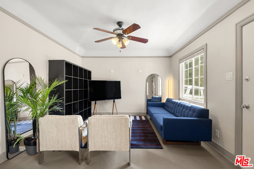 a living room with furniture a chandelier and a window
