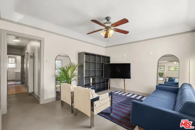 a living room with furniture a chandelier and a flat screen tv