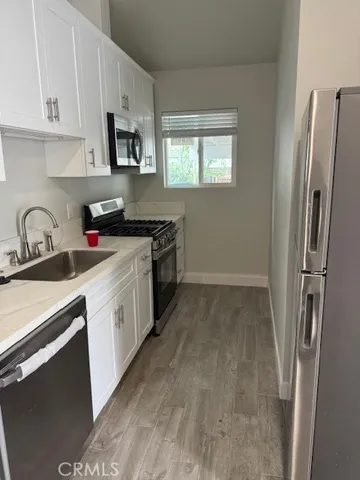 a kitchen with stainless steel appliances granite countertop a refrigerator stove and sink