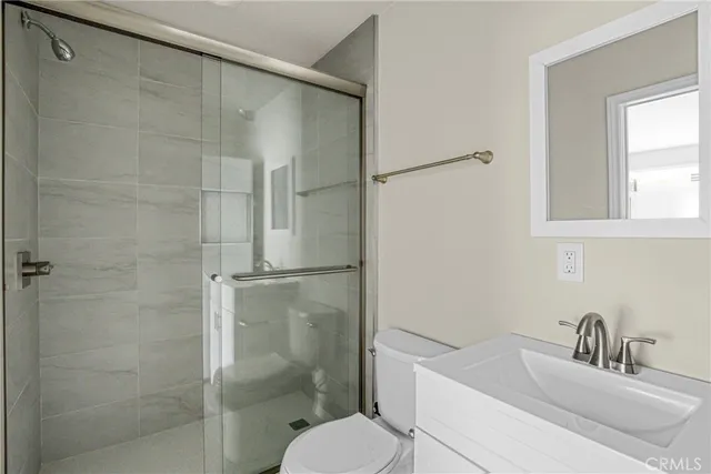 a bathroom with a sink and mirror with toilet