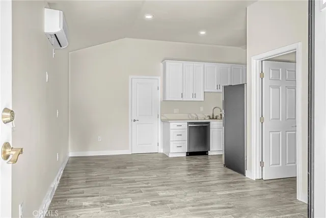a view of kitchen refrigerator and wooden floor