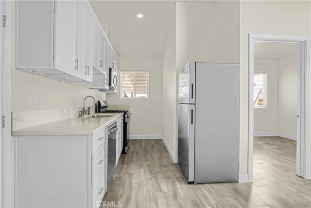 a kitchen with a sink a refrigerator a stove and cabinets