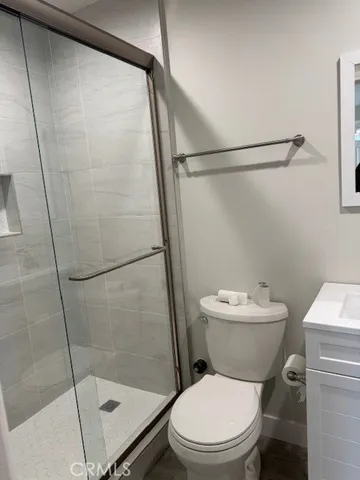 a white toilet sitting next to a shower