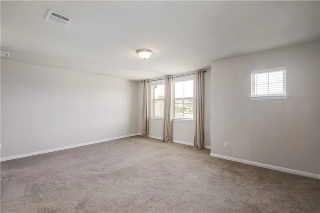 an empty room with windows and closet