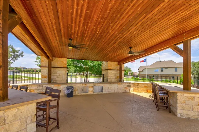 a view of swimming pool of water with lawn chairs and large tree