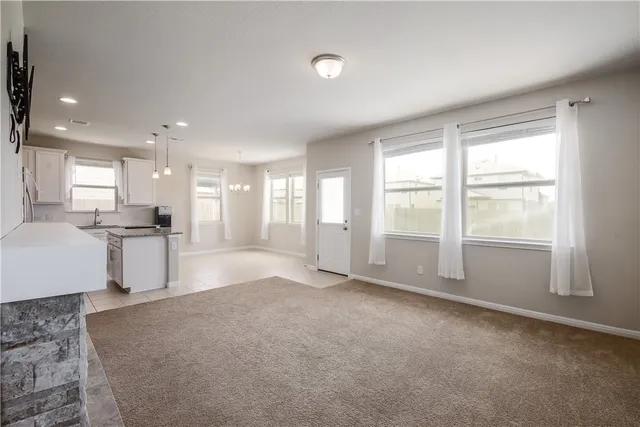 a view of a big room with windows and chandelier