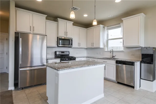a kitchen with stainless steel appliances granite countertop a refrigerator stove microwave and sink