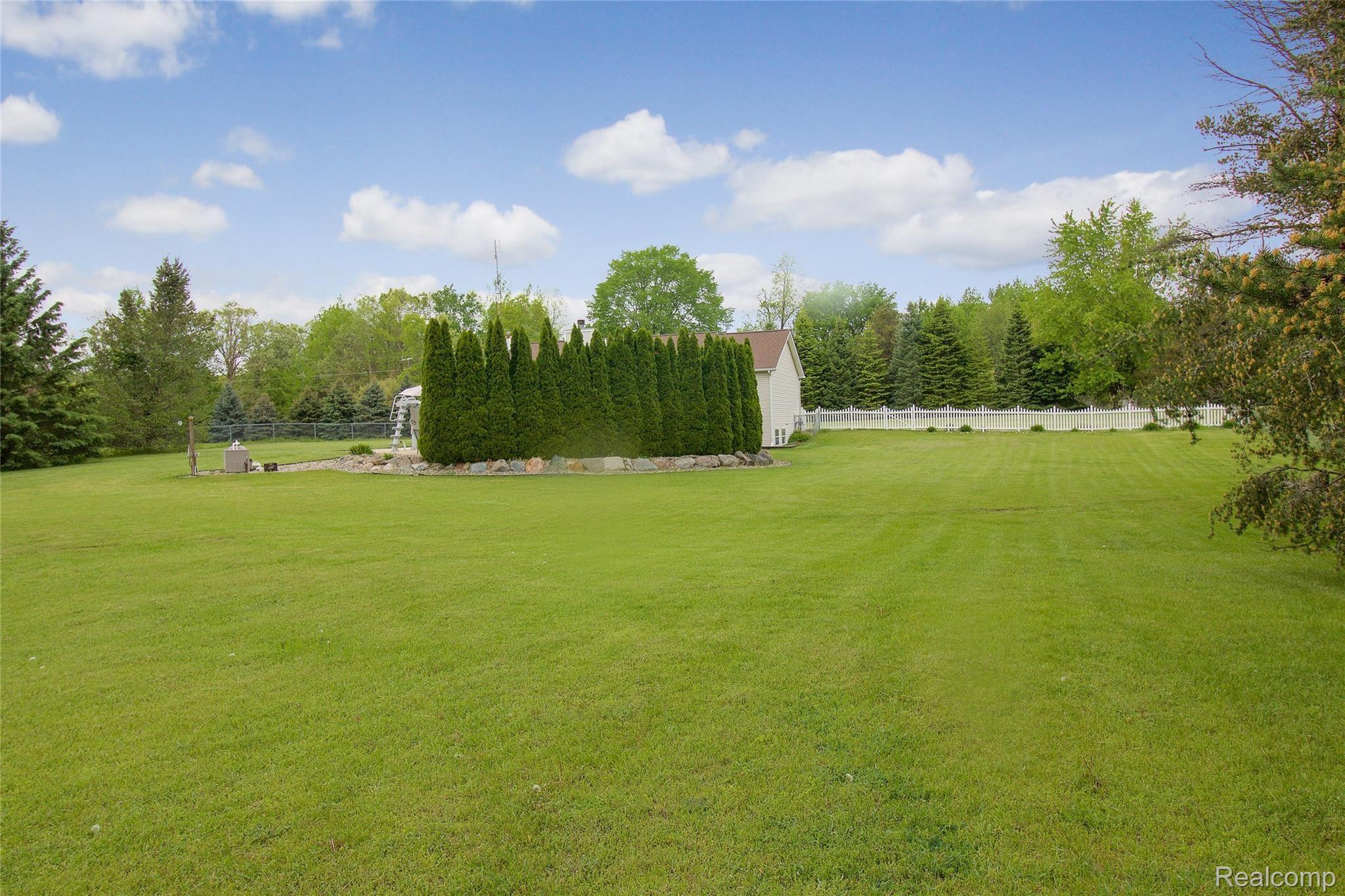 2552 Swarthout Road Pinckney, MI 48169 - Photo 43 of 50 Wall of Arborvitaes around 2 sides of the pool