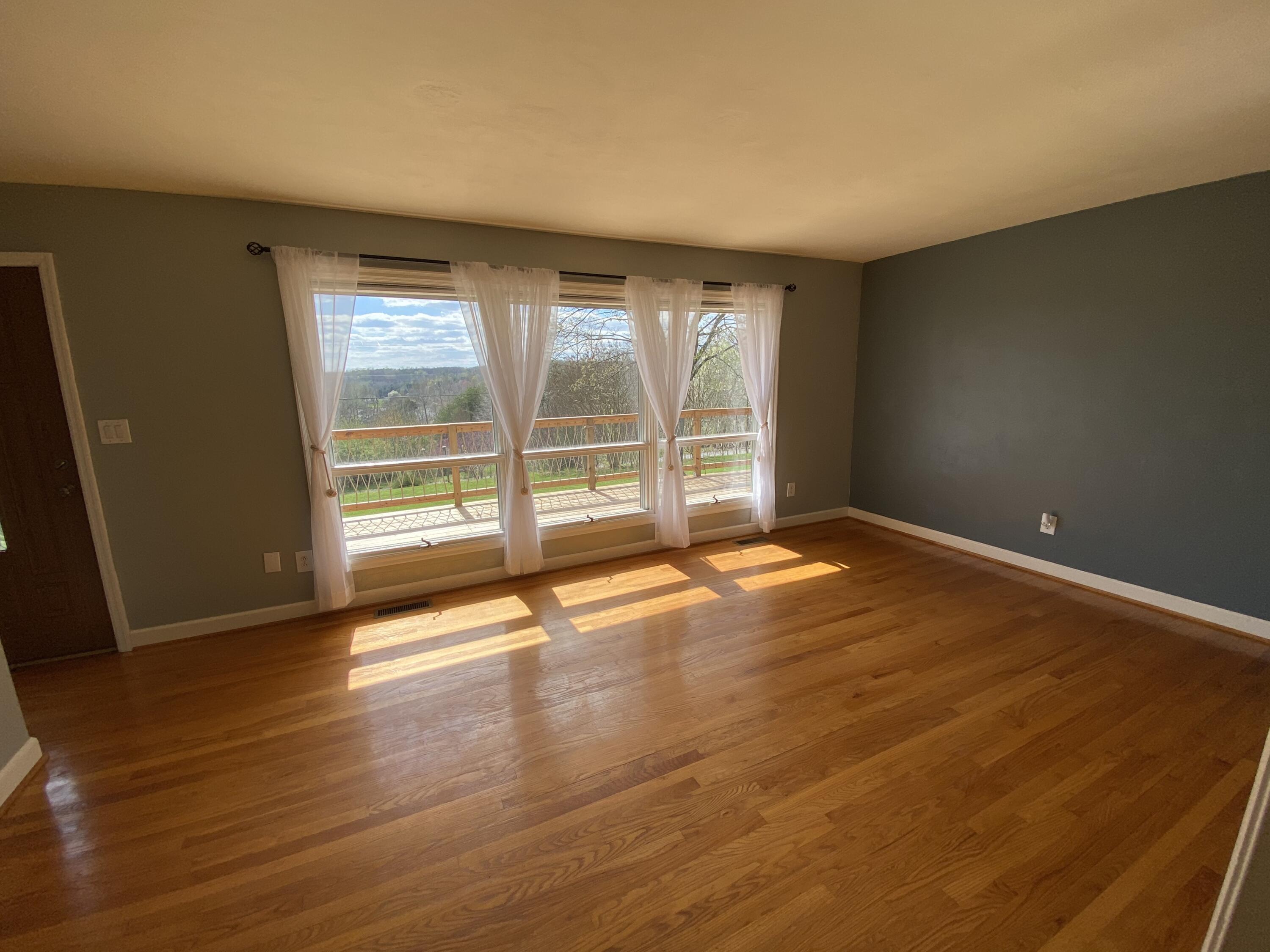 1888 Trails End Road Goodview, VA 24095 - Photo 8 of 18 an empty room with wooden floor and windows