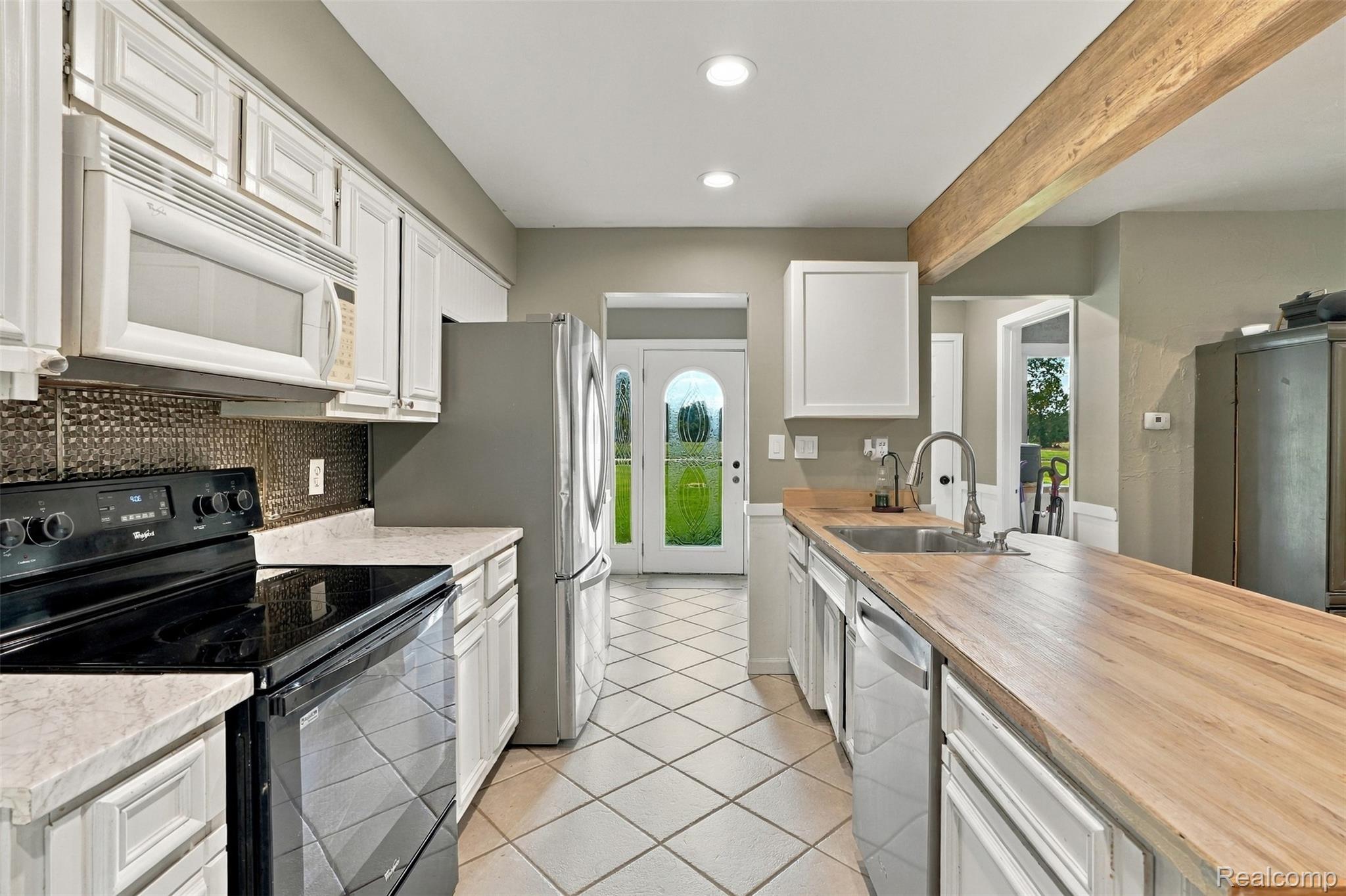 26516 Romine Road New Boston, MI 48164 - Photo 11 of 62 Kitchen featuring white cabinetry, wood-finish countertops, stainless steel appliances, and diagonal tile flooring