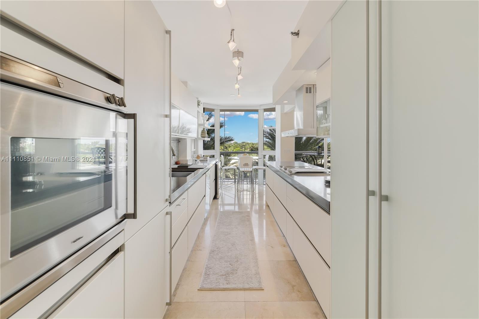 8925 Collins Avenue, Unit 5E Surfside, FL 33154 - Photo 2 of 54 a kitchen with stainless steel appliances kitchen island granite countertop lots of counter top space and wooden floor