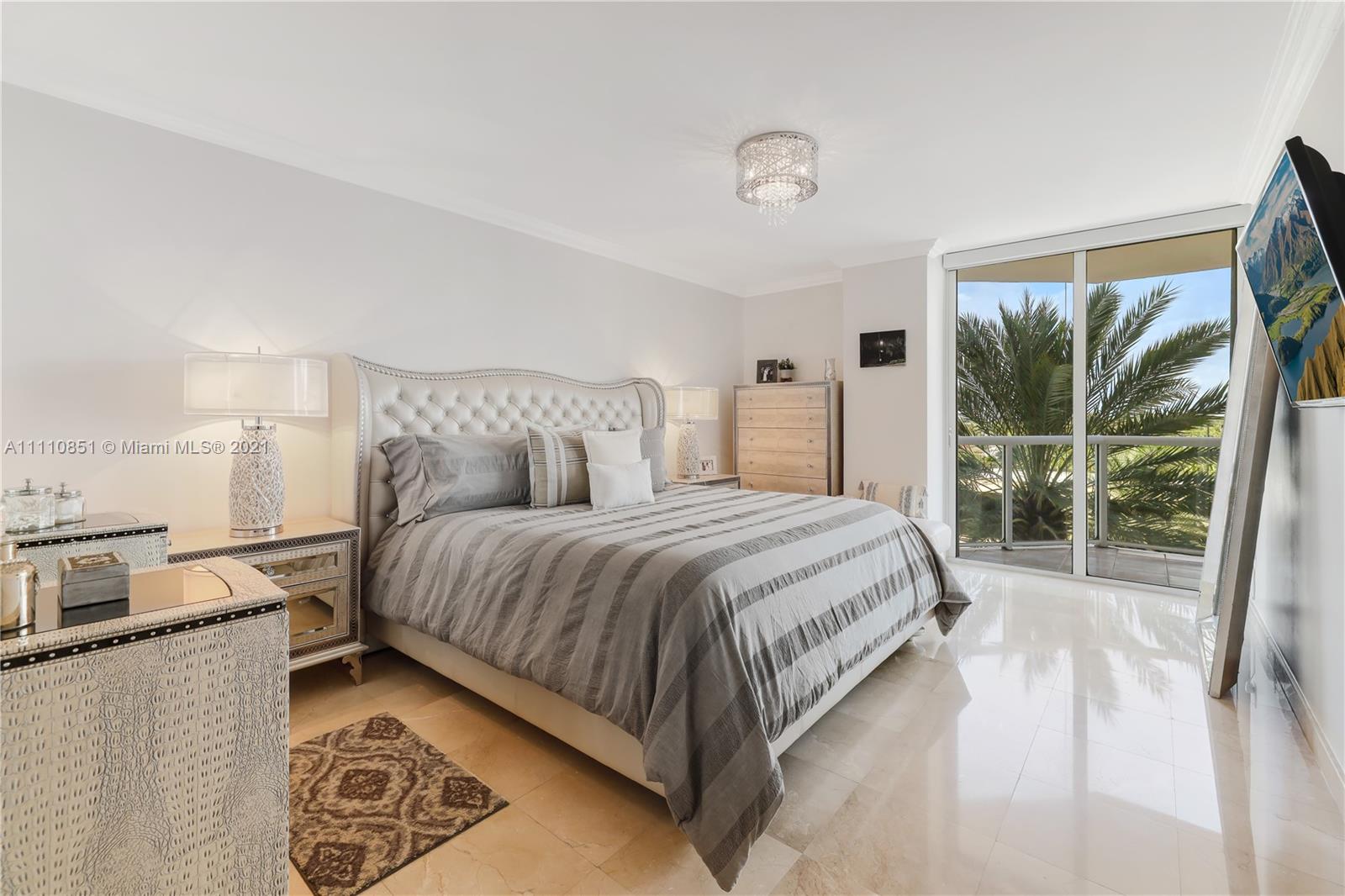 8925 Collins Avenue, Unit 5E Surfside, FL 33154 - Photo 21 of 54 a bedroom with a bed lamp and a large window