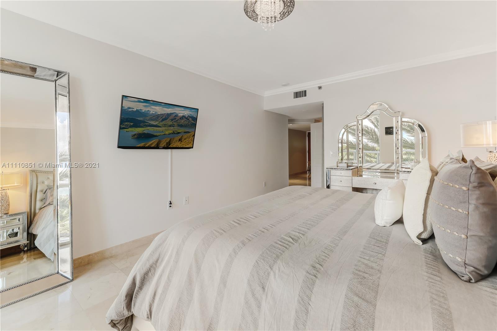 8925 Collins Avenue, Unit 5E Surfside, FL 33154 - Photo 24 of 54 a spacious bedroom with a bed and a flat screen tv