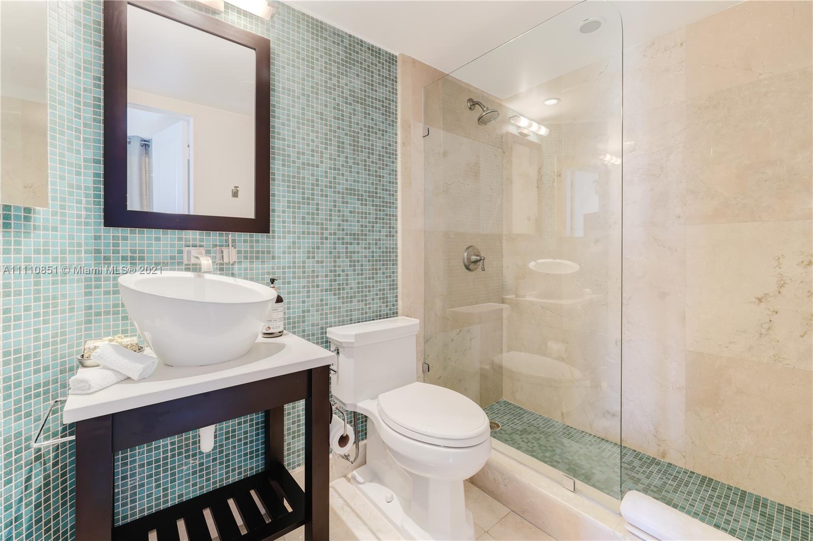 8925 Collins Avenue, Unit 5E Surfside, FL 33154 - Photo 35 of 54 a bathroom with a toilet a sink and mirror