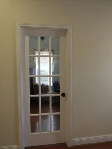a view of a small space with wooden floor and a fan