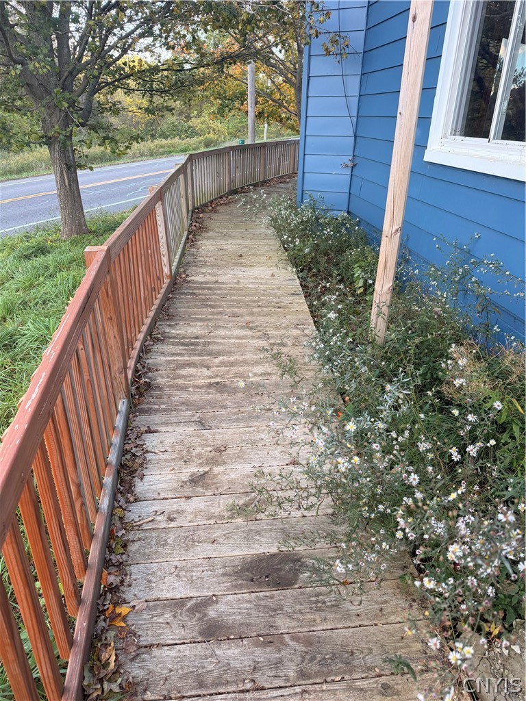 2025 Apulia Road LaFayette, NY 13084 - Photo 12 of 16 An elevated wooden walkway with railings runs alongside the side of the home.