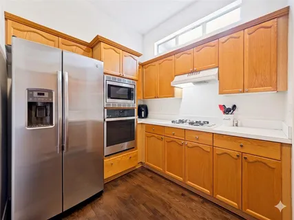 a kitchen with stainless steel appliances a sink and a refrigerator