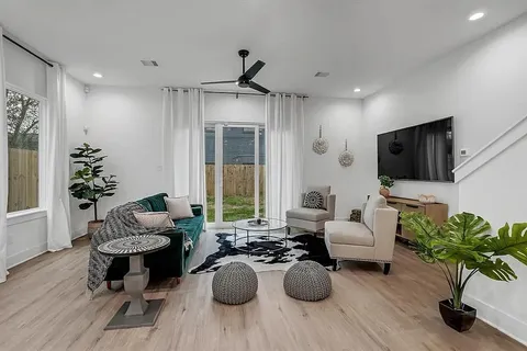 a living room with furniture potted plant and a flat screen tv