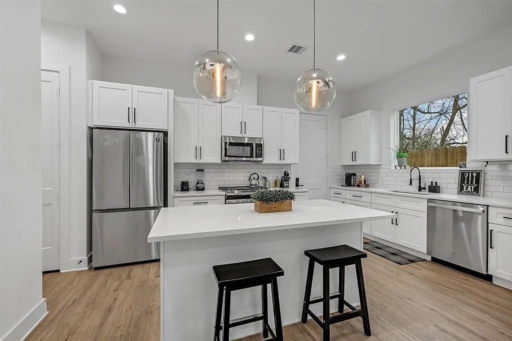 6814 Burkett Street, Unit B Houston, TX 77021 - Photo 8 of 22 a kitchen with white cabinets stainless steel appliances and kitchen island