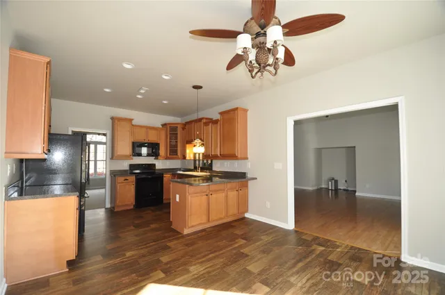 a kitchen with stainless steel appliances granite countertop sink stove top oven and refrigerator