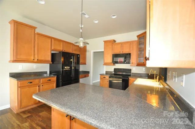 a kitchen with stainless steel appliances granite countertop a sink a stove and a refrigerator