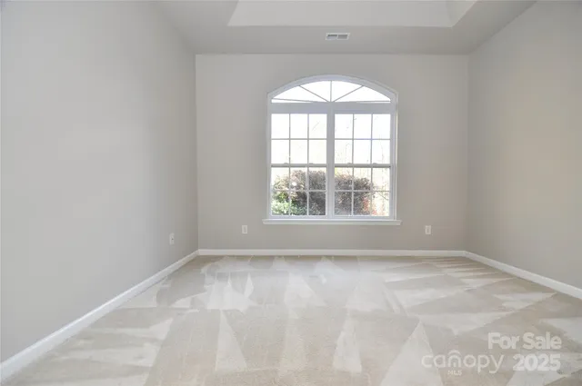 a view of a house with large tree and wooden fence
