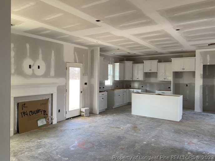 7740 Rufus Johnson Road Fayetteville, NC 28312 - Photo 2 of 11 a large kitchen with a fireplace and cabinets