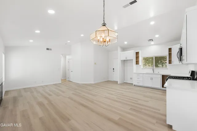 a view of a kitchen with a sink and dishwasher a refrigerator with wooden floor