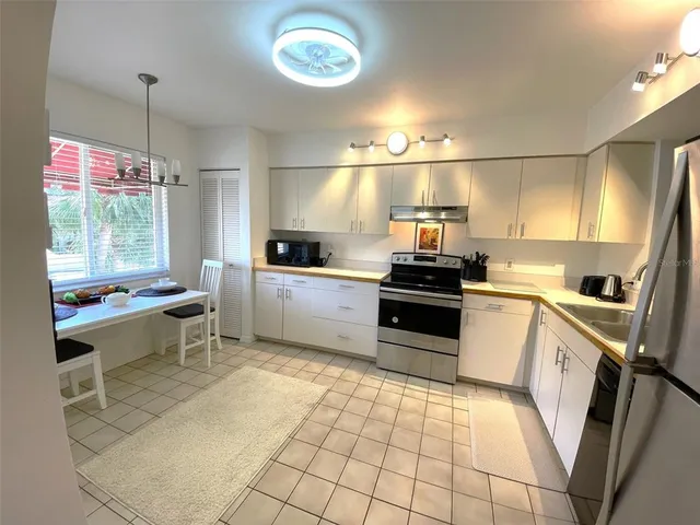 a kitchen with granite countertop a stove a sink and a refrigerator