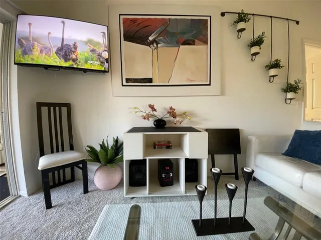 a living room with furniture a flat screen tv and a floor to ceiling window