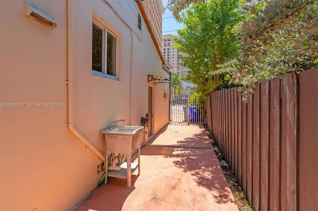 a view of a backyard with wooden fence and large trees