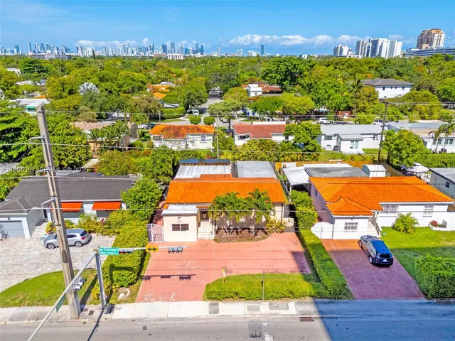 an aerial view of residential houses with outdoor space and parking