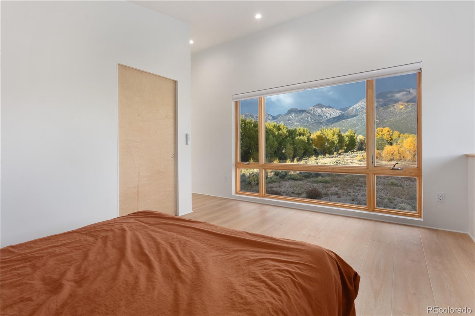 1276 Sycamore Road Crestone, CO 81131 - Photo 19 of 48 a bedroom with a bed and a large window