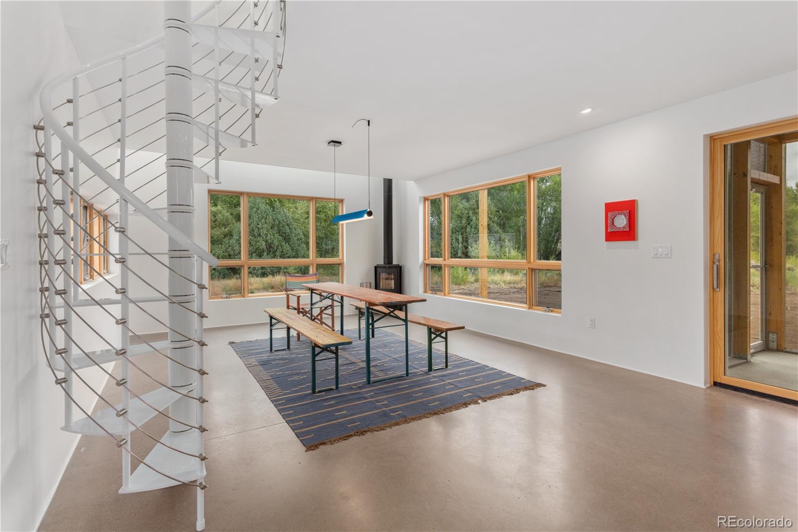1276 Sycamore Road Crestone, CO 81131 - Photo 35 of 48 a dining room with wooden floor and large windows