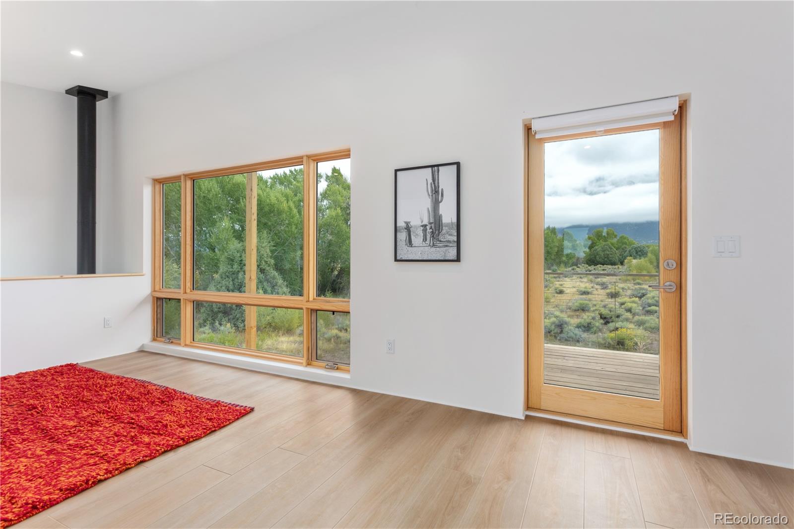 1276 Sycamore Road Crestone, CO 81131 - Photo 37 of 48 a view of an empty room with wooden floor and a window