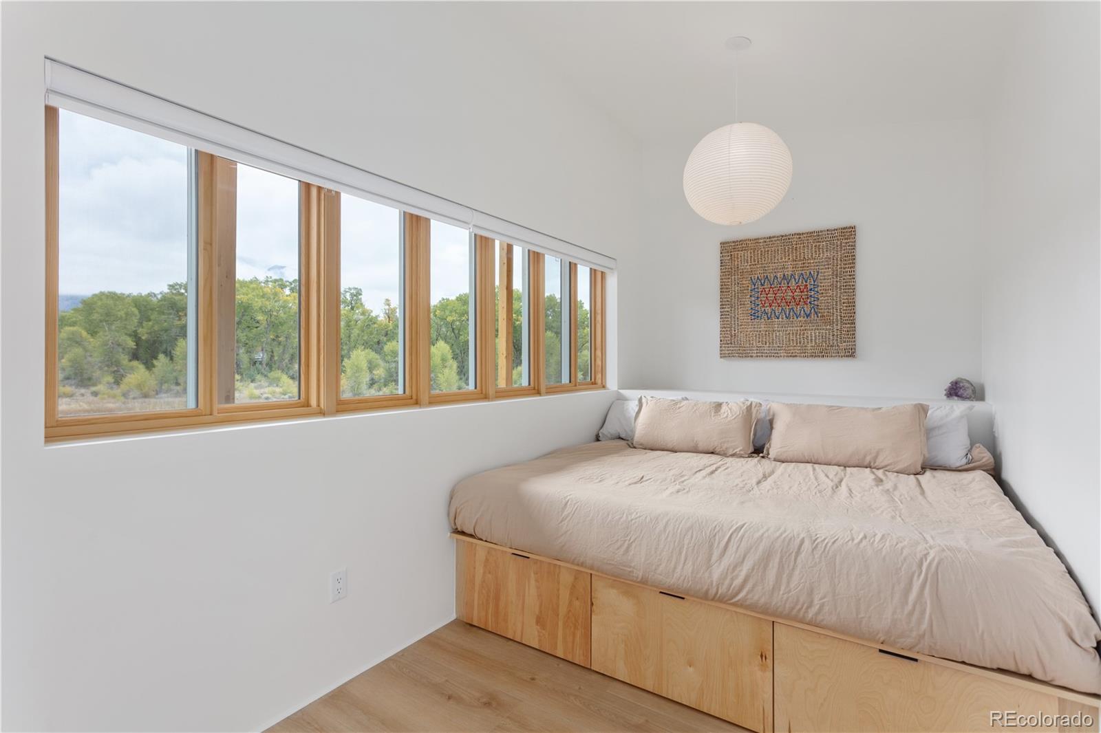 1276 Sycamore Road Crestone, CO 81131 - Photo 43 of 48 a bedroom with a large bed and a large window