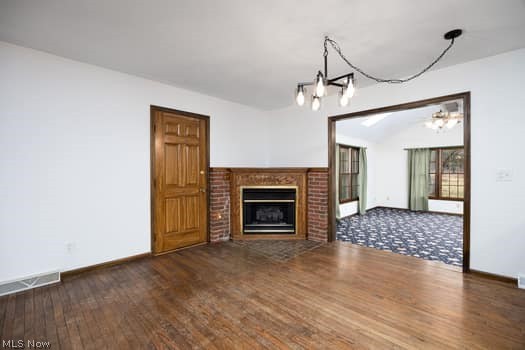 4293 Good Road Seville, OH 44273 - Photo 13 of 35 Unfurnished living room featuring a brick fireplace, dark wood finished floors, and a chandelier