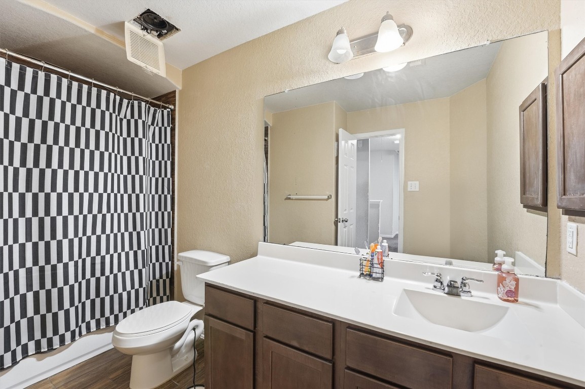 14706 Ruddy Duck Lane Houston, TX 77049 - Photo 17 of 32 a bathroom with a sink a toilet a mirror and shower curtain