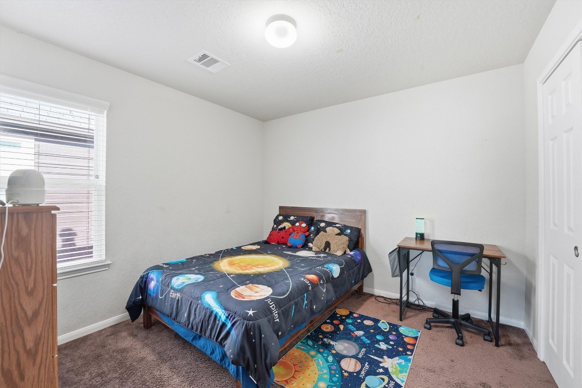 14706 Ruddy Duck Lane Houston, TX 77049 - Photo 18 of 32 a bedroom with a bed and a dresser