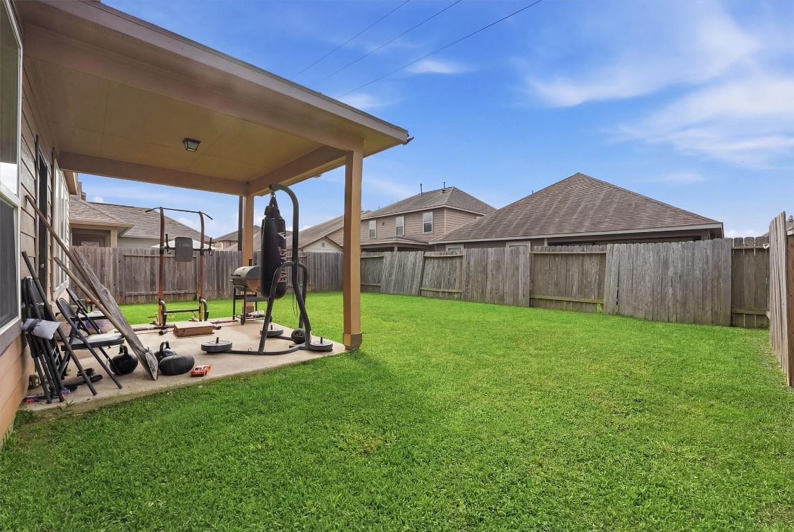 14706 Ruddy Duck Lane Houston, TX 77049 - Photo 26 of 32 a view of a backyard with table and chairs under an umbrella