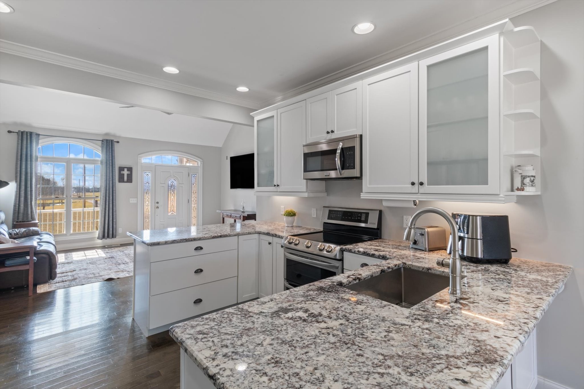 5087 Asbury Road Manchester, TN 37355 - Photo 20 of 33 a kitchen with stainless steel appliances granite countertop a stove top oven a sink a dining table and chairs