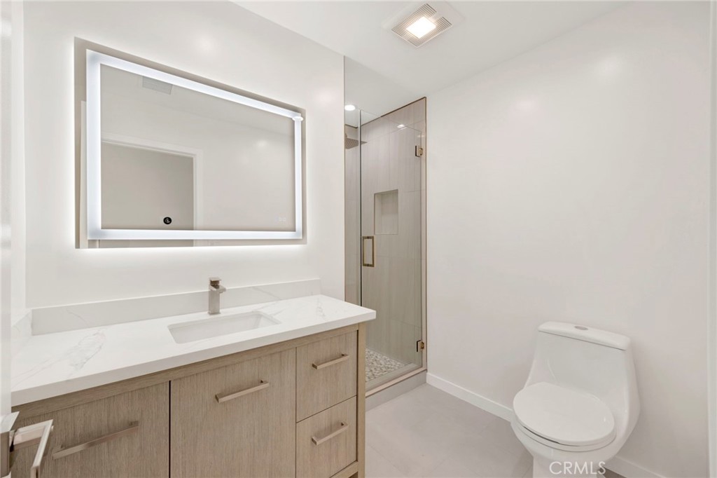 7118 Apperson Street Tujunga, CA 91042 - Photo 13 of 25 a bathroom with a toilet a sink a mirror and vanity