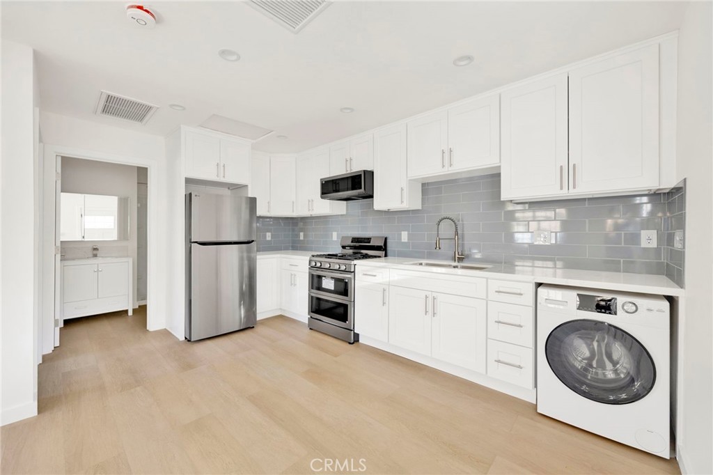 7118 Apperson Street Tujunga, CA 91042 - Photo 18 of 25 a kitchen with a refrigerator sink stove and cabinets