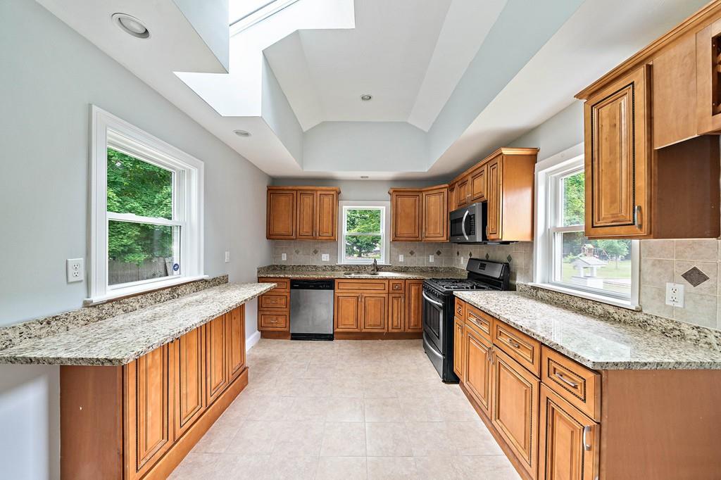 12 Madison Street Taunton, MA 02780 - Photo 11 of 23 a kitchen with stainless steel appliances granite countertop sink stove and refrigerator