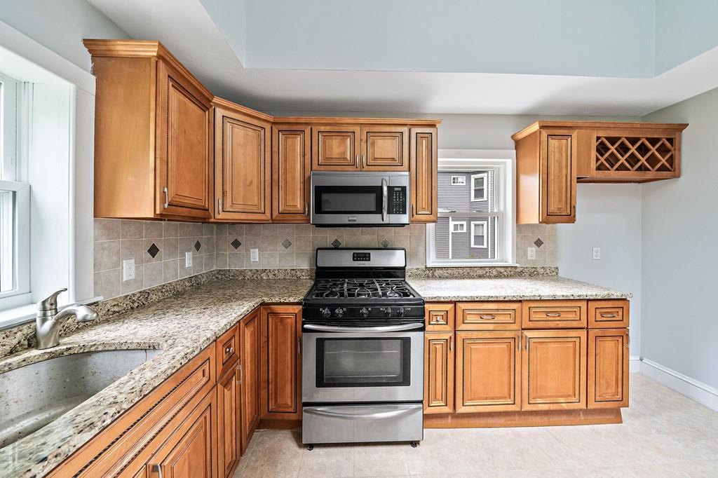 12 Madison Street Taunton, MA 02780 - Photo 12 of 23 a kitchen with granite countertop a stove and a sink