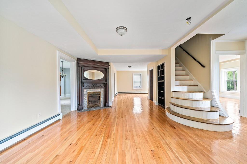 12 Madison Street Taunton, MA 02780 - Photo 3 of 23 a view of a livingroom with wooden floor and fireplace
